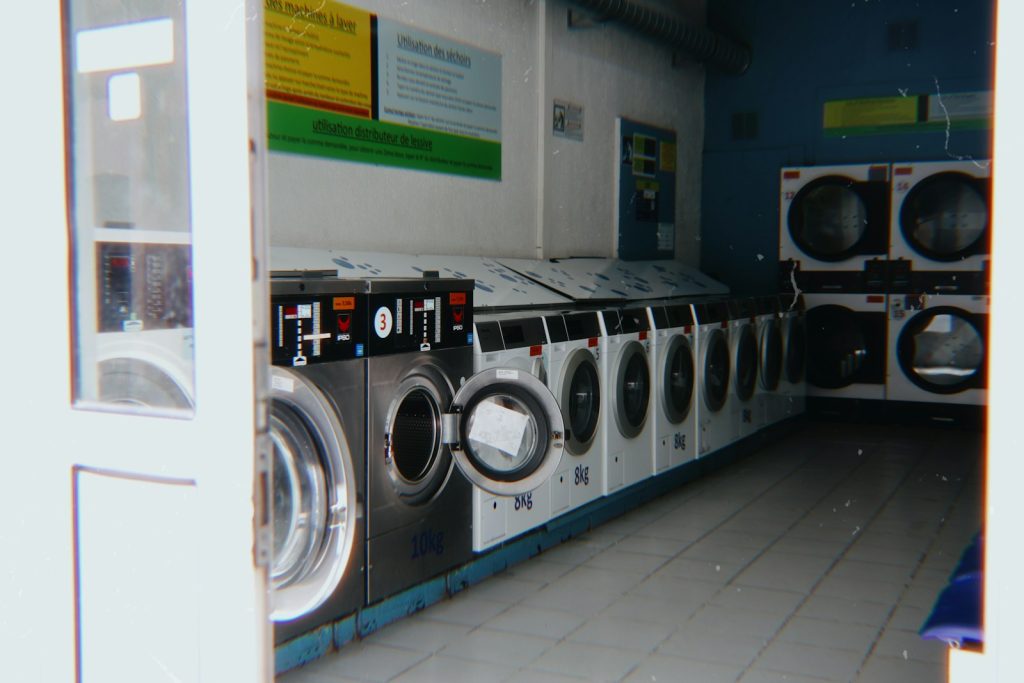 Deretan mesin cuci berbagai kapasitas di outlet laundry koin swalayan
