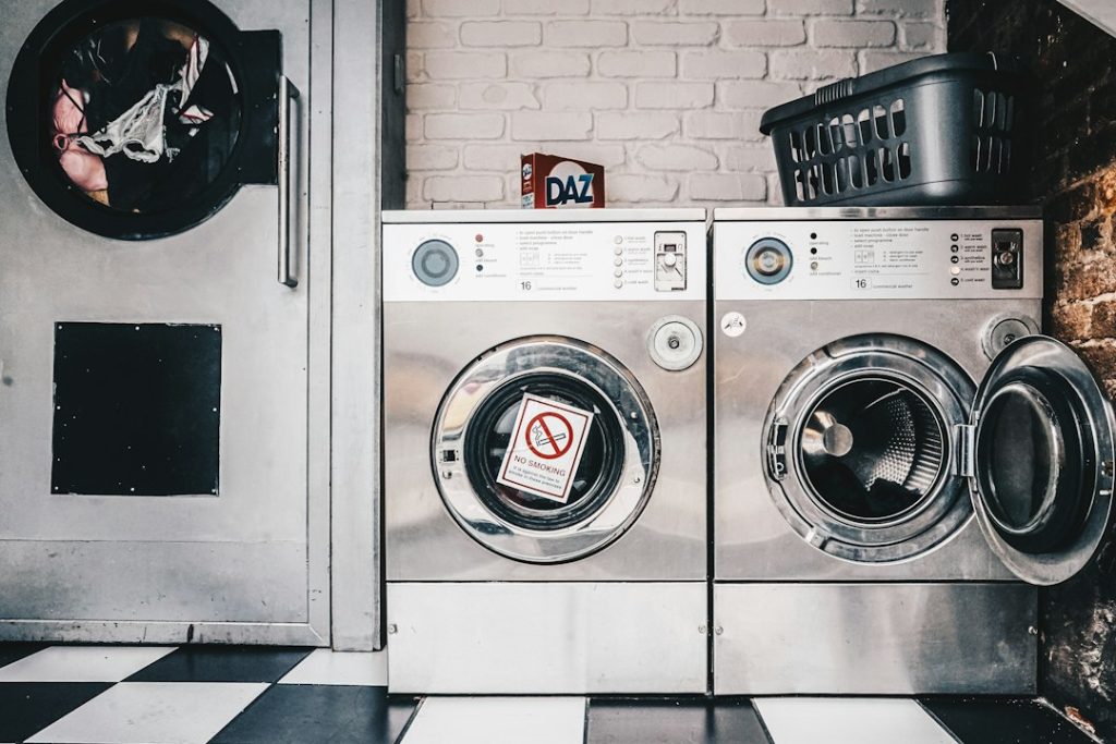 Deretan mesin cuci laundry koin siap pakai di ruang laundry
